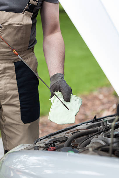 mechanic checking oil level in a car